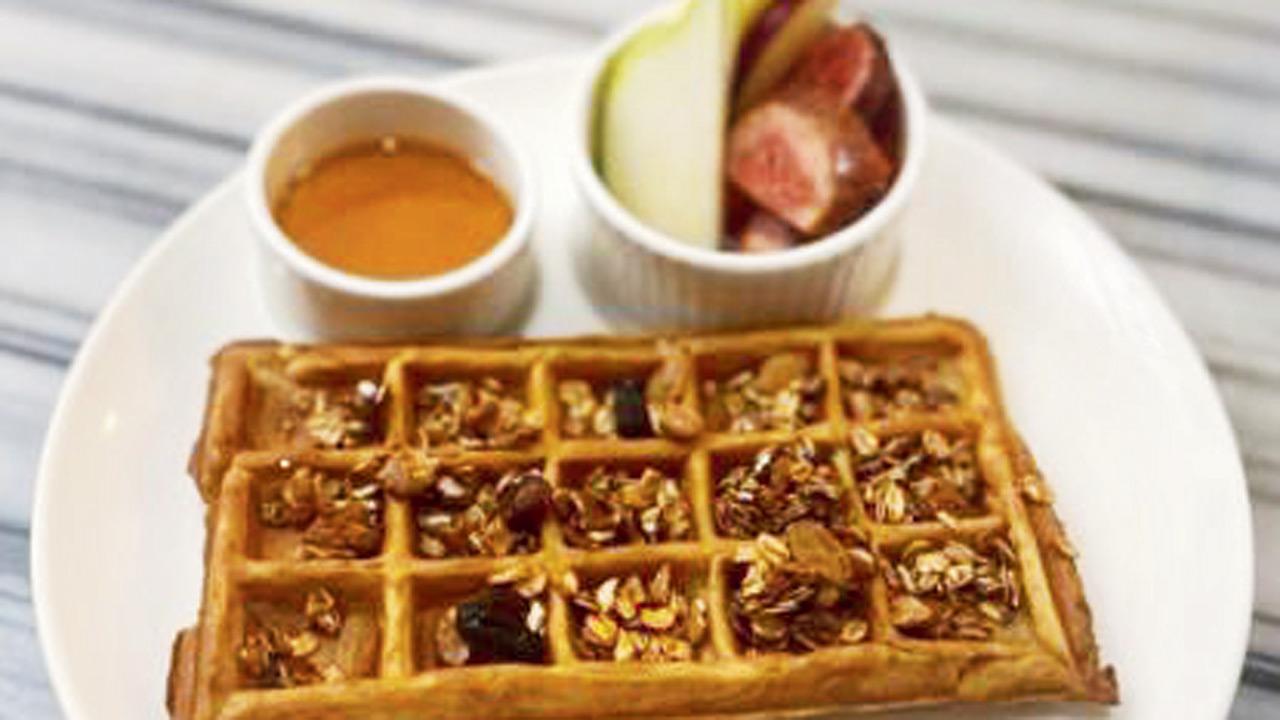 ↑ A portion of granola waffles served with honey and fruit slices
