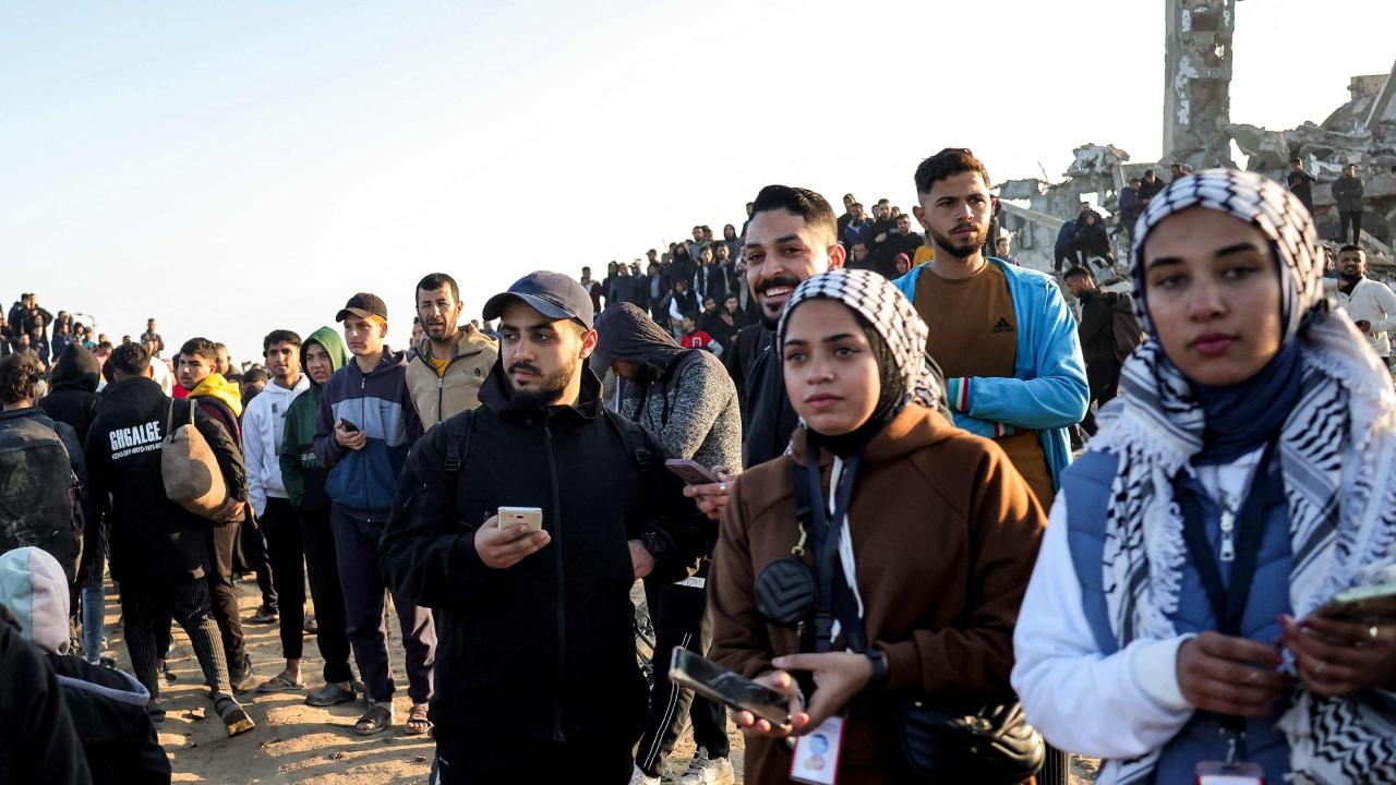 Joyous crowds of Palestinians, some holding babies or pushing wheelchairs, walked along a seaside road all day and into the night, carrying bedrolls, bottles of water and other belongings. A few armed, masked Hamas fighters flashed a victory sign. The crowd was watched over by Israeli tanks on a nearby hill