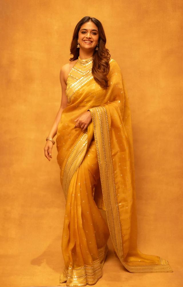 This stunning orange drape paired with a matching blouse made her look like a queen. Keerthy left her hair open in soft curls and wore minimal makeup