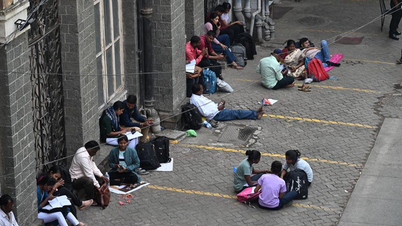 Candidates engage in last-minute preparation and revision outside Anjuman Islam Allana School in Fort