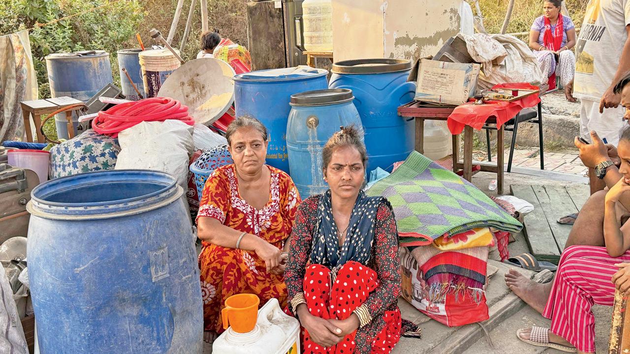 Displaced residents living on footpath with their belongings