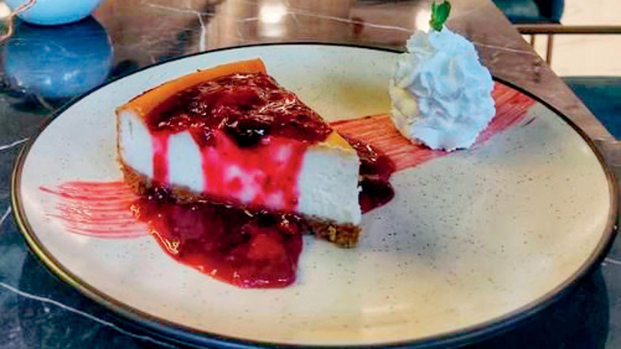 A slice of red wine and berry  coulis cheesecake