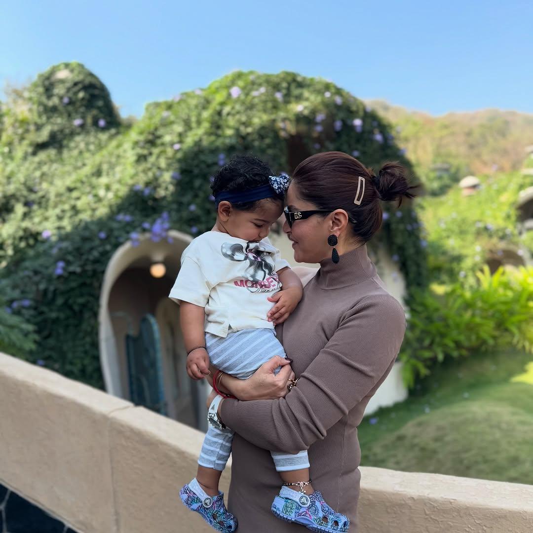 In this picture, Rubina can be seen holding one of their baby girls close as they pose for a candid picture