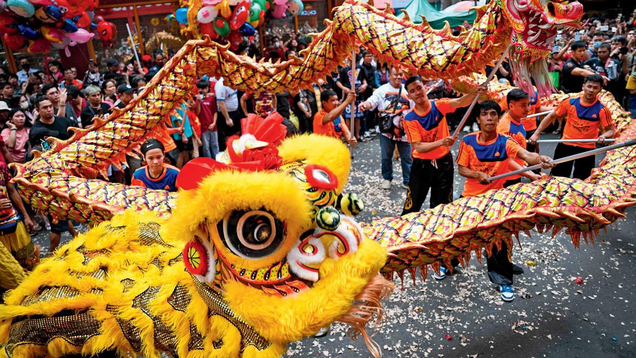 Dragon and lion dancers perform on a street at Chinatown in Manila. Pics/AFP