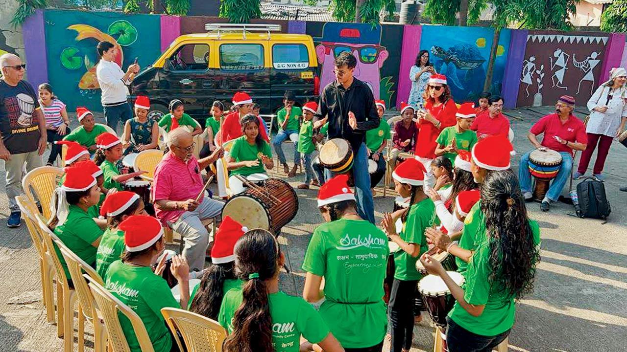 Members participate in a community drum jam at Thane