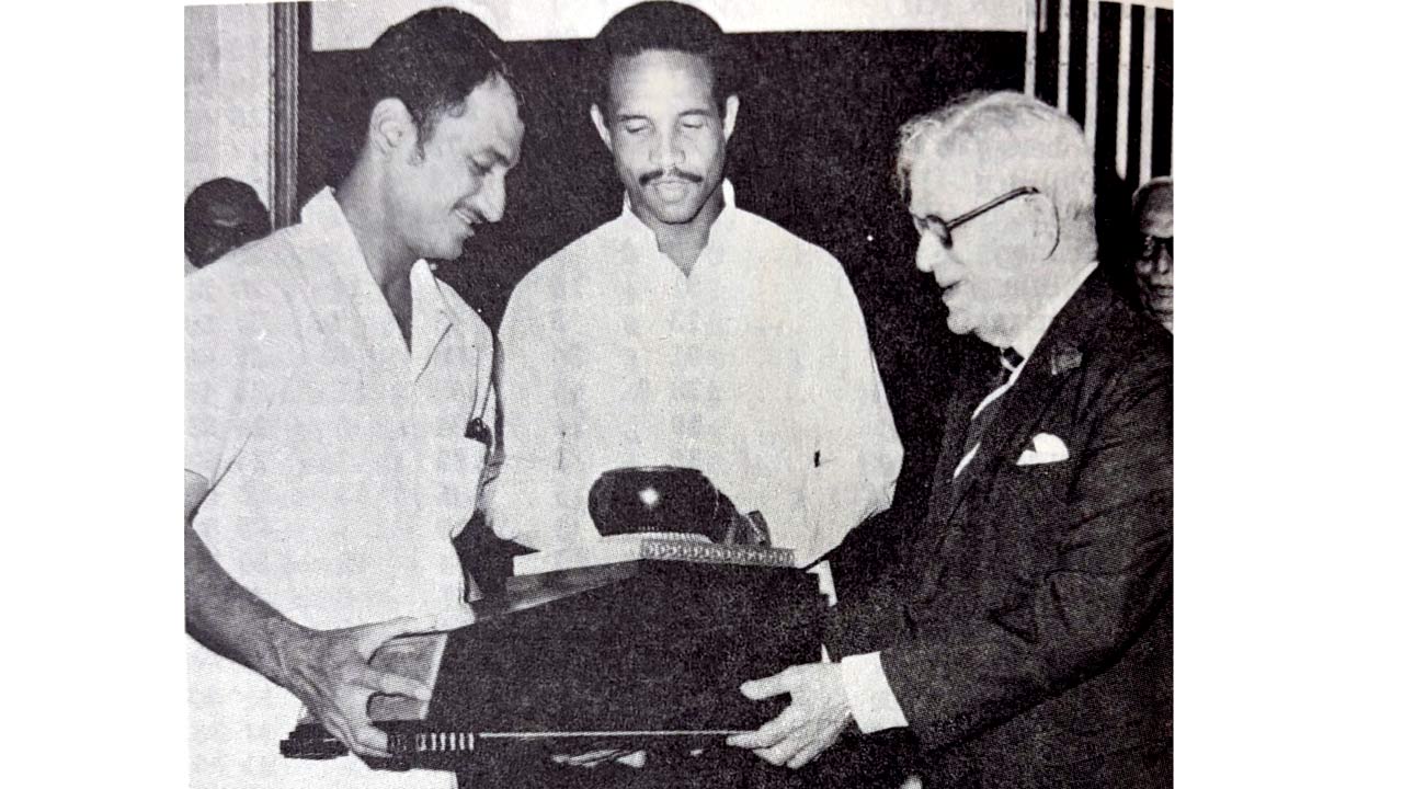 India skipper Ajit Wadekar (left) receives the 1970-71 series-winning trophy from Sir Errol Dos Santos, President of Queen’s Park Cricket Club at a cocktail party for members of the West Indian and Indian teams in Trinidad. WI captain Garry Sobers is in the centre. Pic/Courtesy Trinidad Cricket Council Yearbook 1971