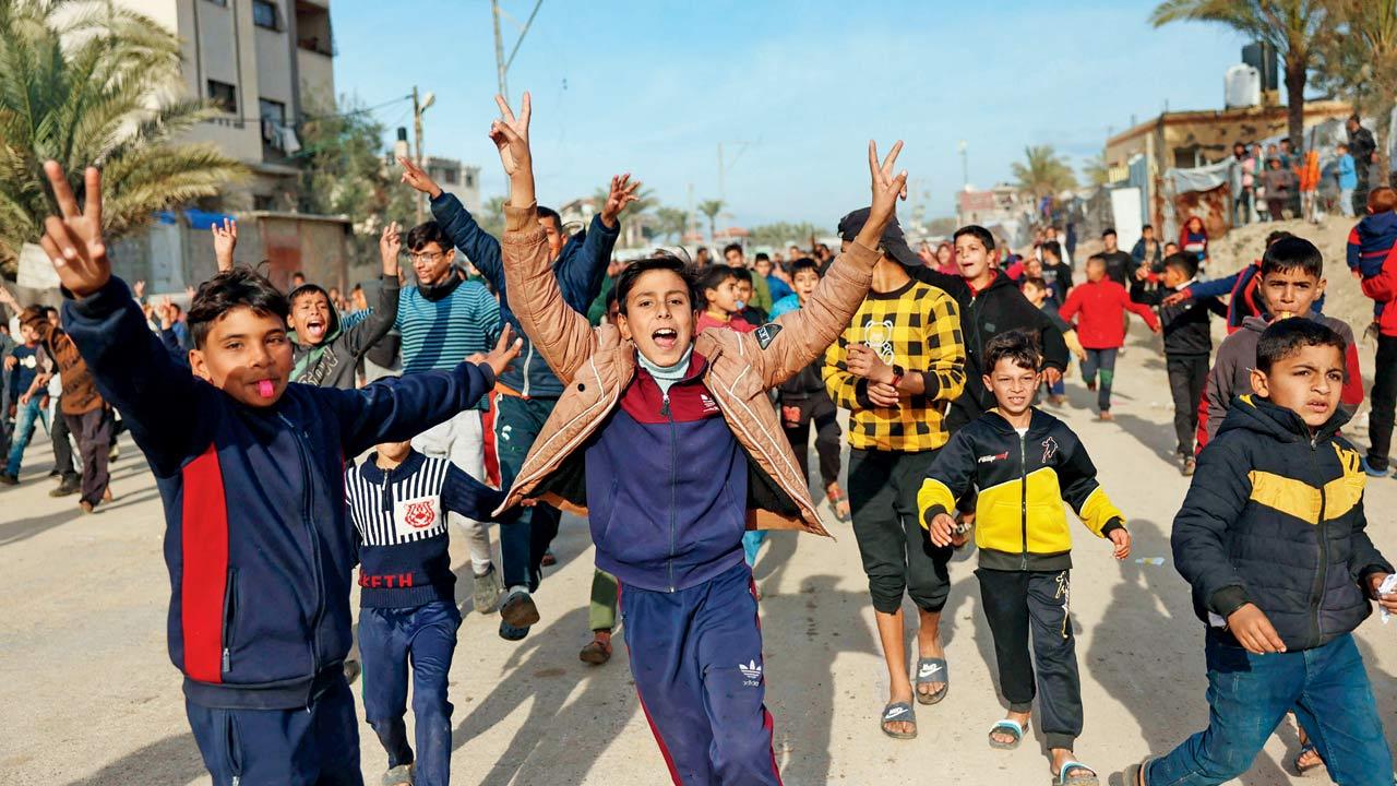 Displaced Palestinians wave national flags and children cheer in Nuseirat in celebration as they return to Rafah, in the southern Gaza Strip, on Sunday. Pic/AFP