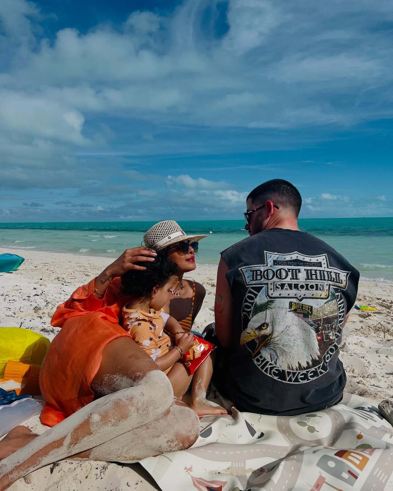 Priyanka and Nick engage in a conversation as their daughter Malti plays with the sand
