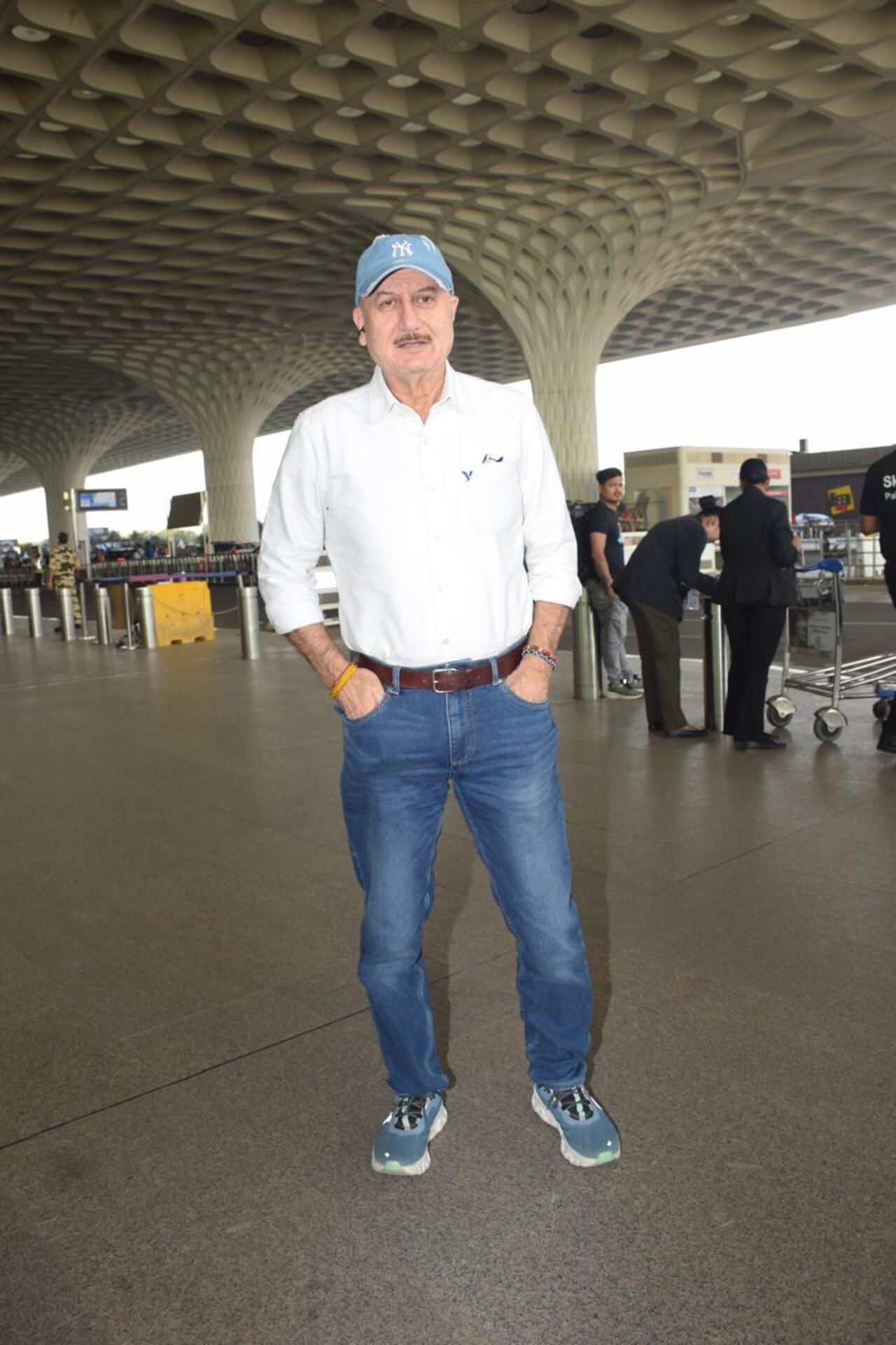 Anupam Kher strikes a pose for the paparazzi at the airport