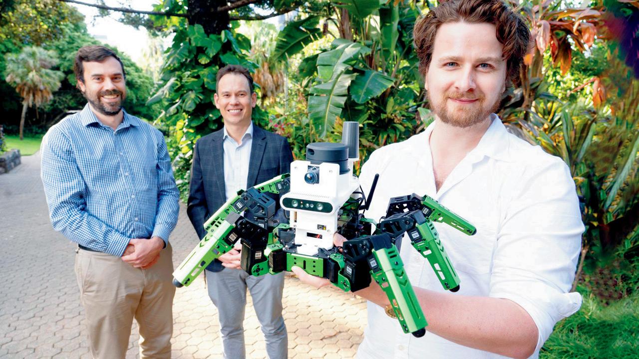 Dr Tobias Fischer, Professor Michael Milford. Dr Adam Hines, holds his ‘green’ robot. Pic/QUT