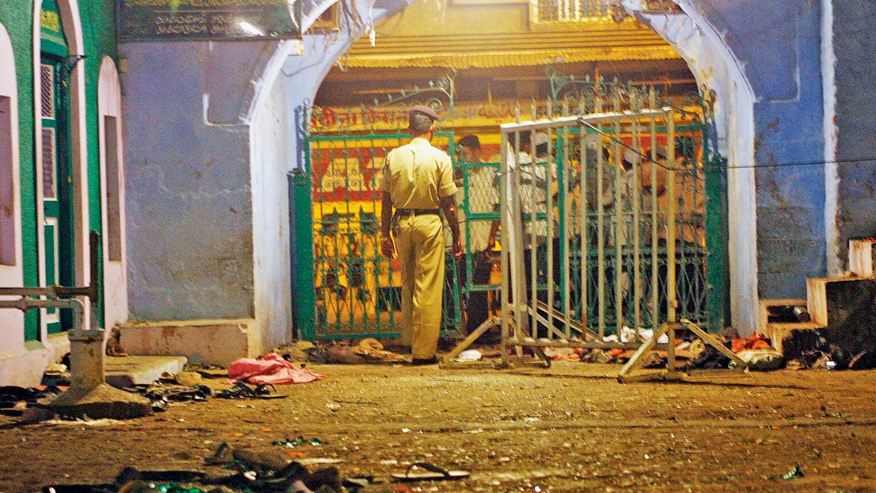 A police official keeps guard at the gate of the Hamidiya Mosque where three bombz exploded after Friday prayers at Malegaon in the western Indian state of Maharashtra, on September 9, 2006. pic/Getty Images