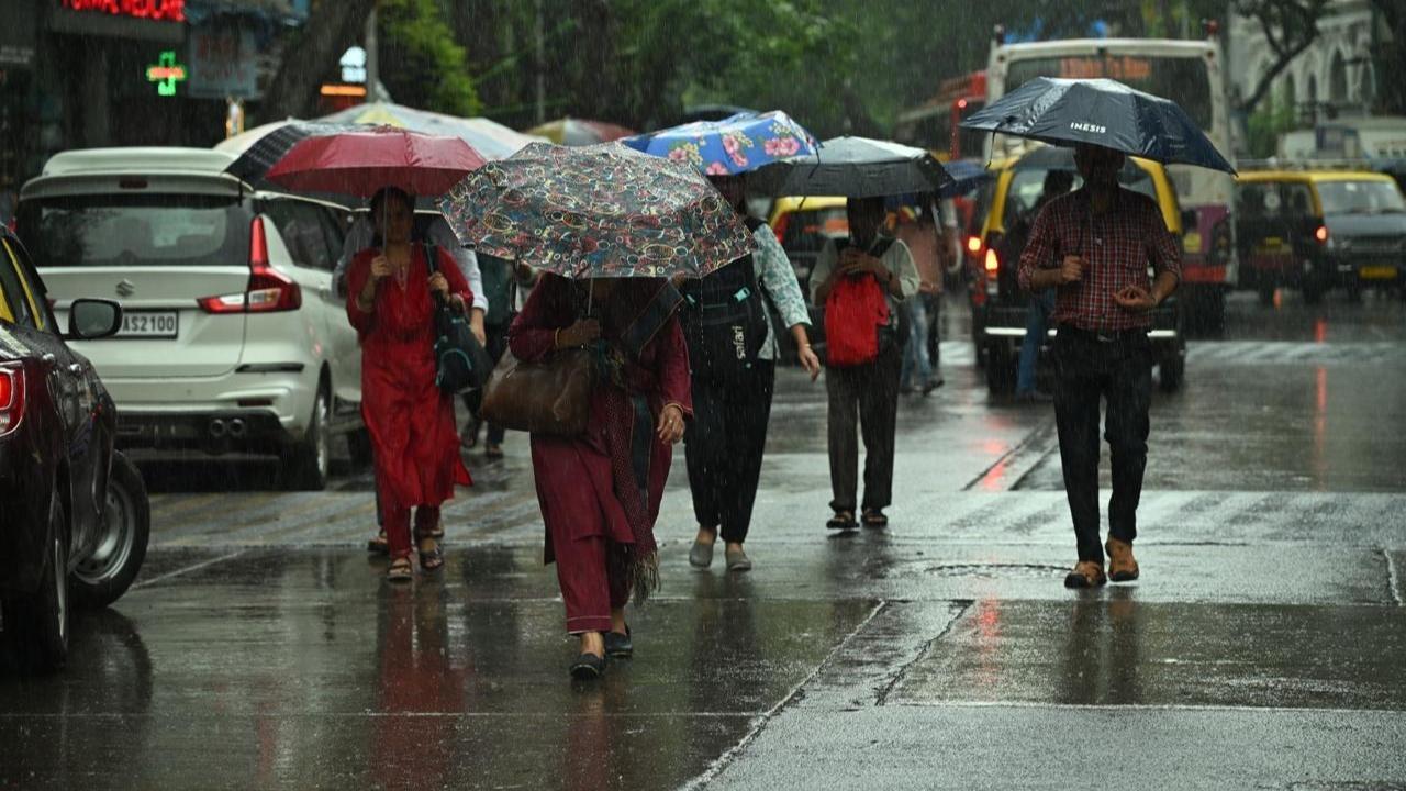 In Photos: People take cover as rain lashes parts of Mumbai