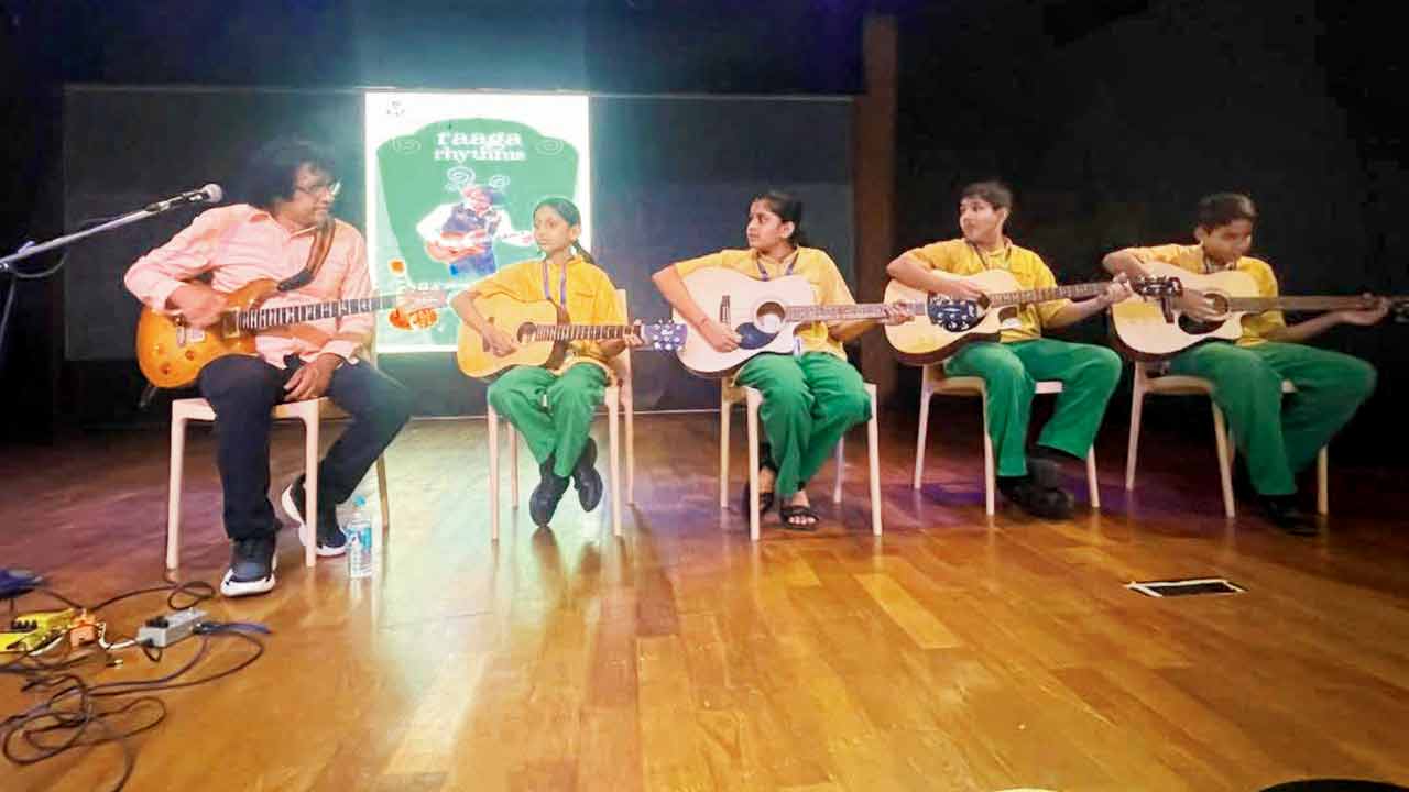R Prasanna (extreme left) plays a few chords with the children on stage. Pic Courtesy/@tenderroots India