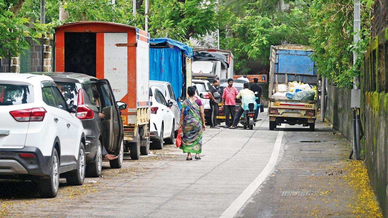 Cars parked along one side of the interior lane, where footpaths are missing or unusable