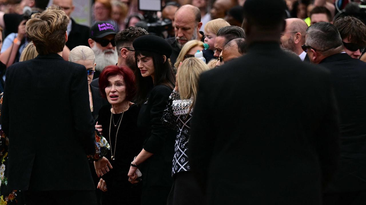 Ozzy Osbourne's widow Sharon Osbourne (C) reacts at the Black Sabbath Bridge bench on Broad Street during a funeral procession for Ozzy Osbourne