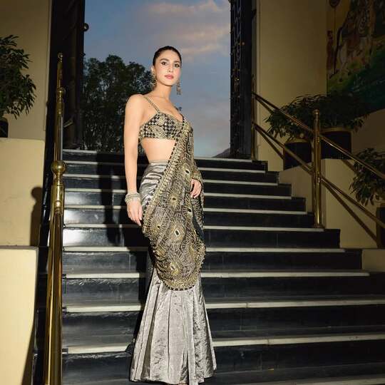 Vaani Kapoor stuns in a glamorous indo-western look, donning a metallic lehenga with a heavily embellished blouse and draped dupatta.