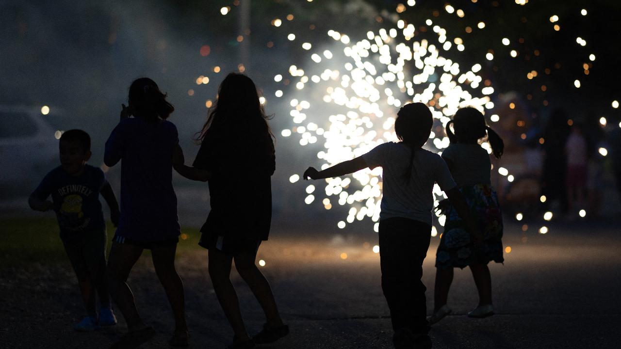 Kids react to fireworks ignited on the street as they wait for the start of the city's annual Independence Day fireworks display on July 4 in Storm Lake, Iowa