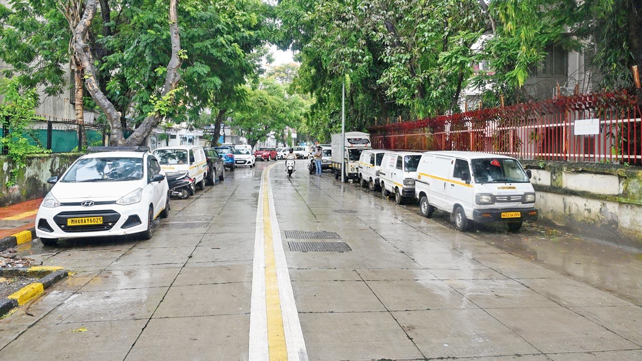 Vehicles occupy one side of the road while the other lacks a functional footpath, forcing pedestrians onto the street. PICS/SATEJ SHINDE
