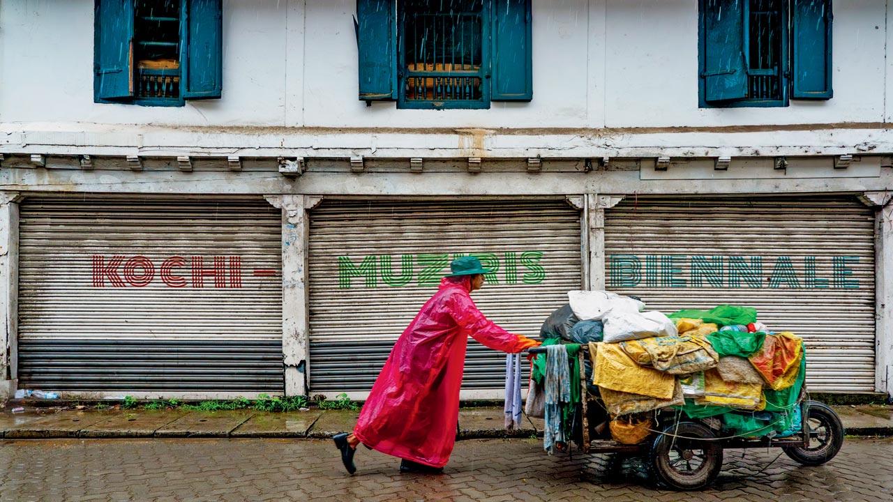 A man pushes his cart past a wall bearing Biennale lettering in  Mattancherry. PICS COURTESY/KOCHI-MUZIRIS BIENNALE