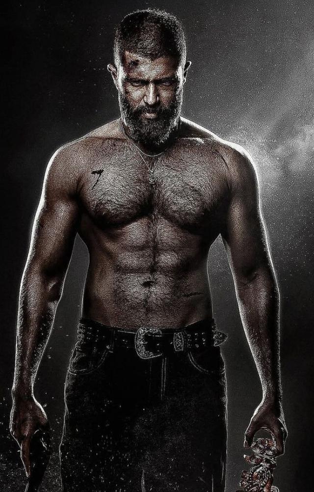 Vijay appears in a fierce avatar in Kingdom, bare-chested, with a chiselled physique, heavy beard, scars on his face and body, holding a gun and a prop. 