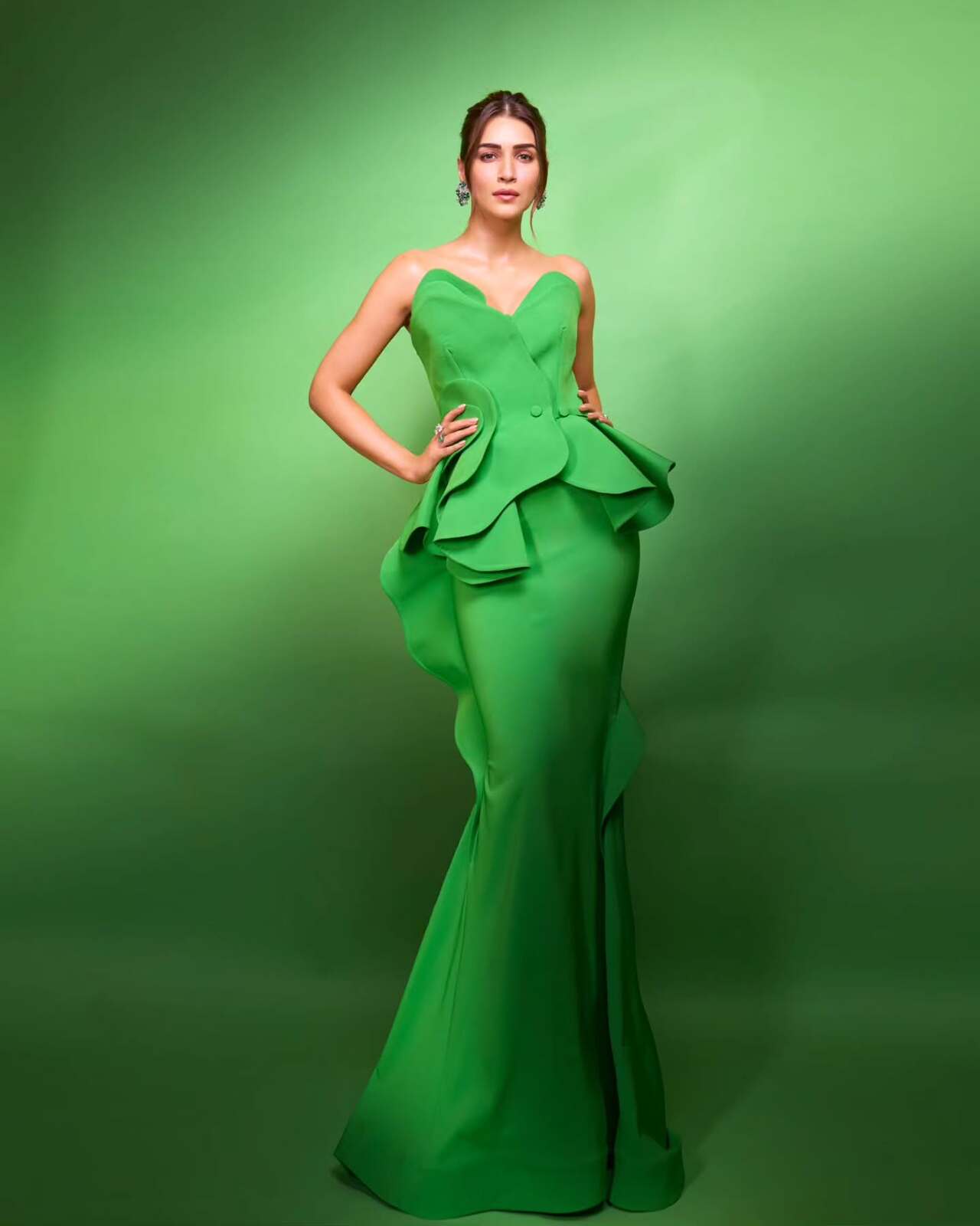 Not everyone can pull off a green like that, but Kriti exudes grace in this bright green off-shoulder gown. The outfit features a layered peplum design with classy statement earrings.