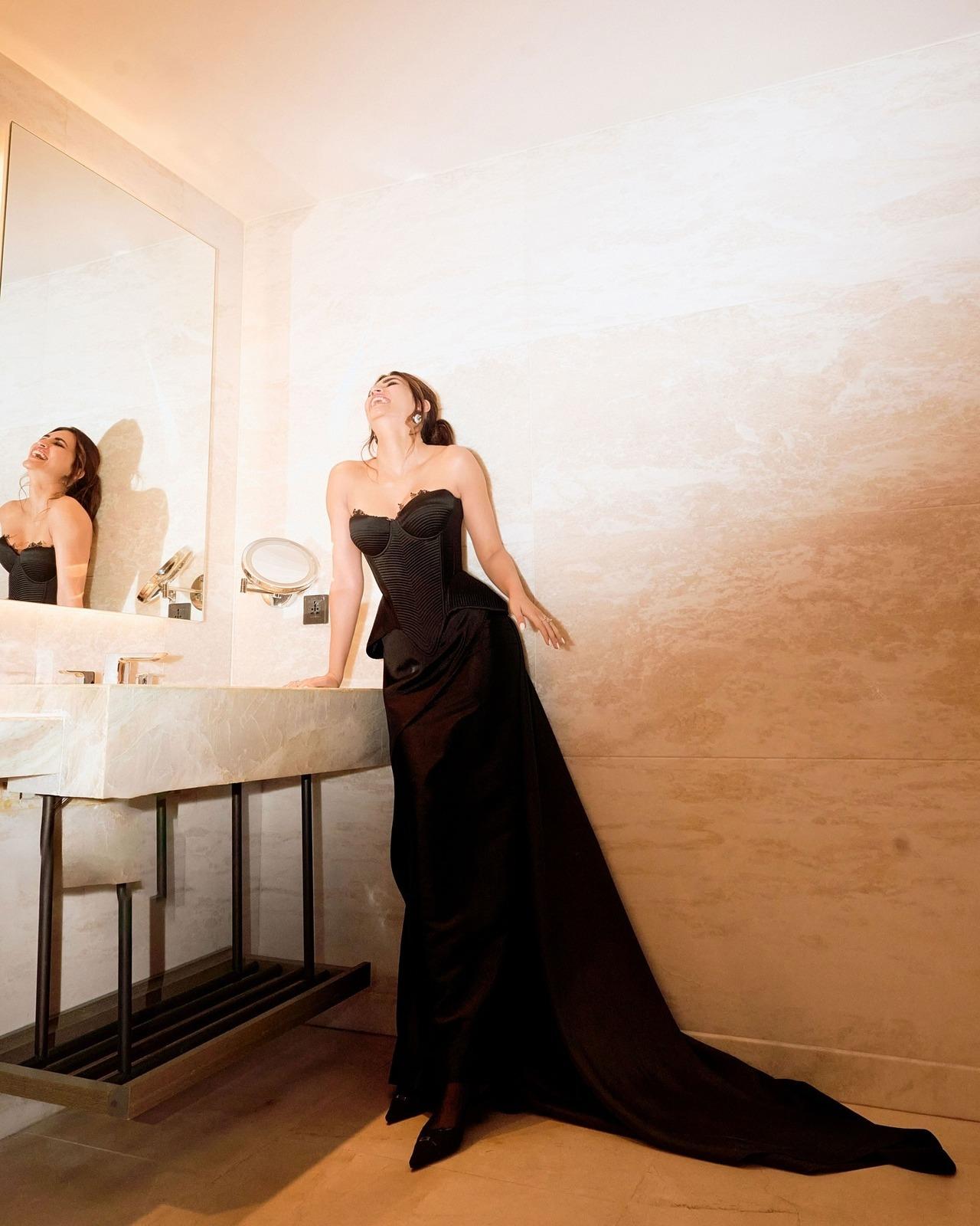 Sultry and chic, Kriti looked gorgeous in an all-black corset gown featuring a ribbed, structured bodice with delicate black lace and a sweetheart neckline. It has a voluminous skirt with a trail that added grace, along with chunky diamond-encrusted silver earrings.