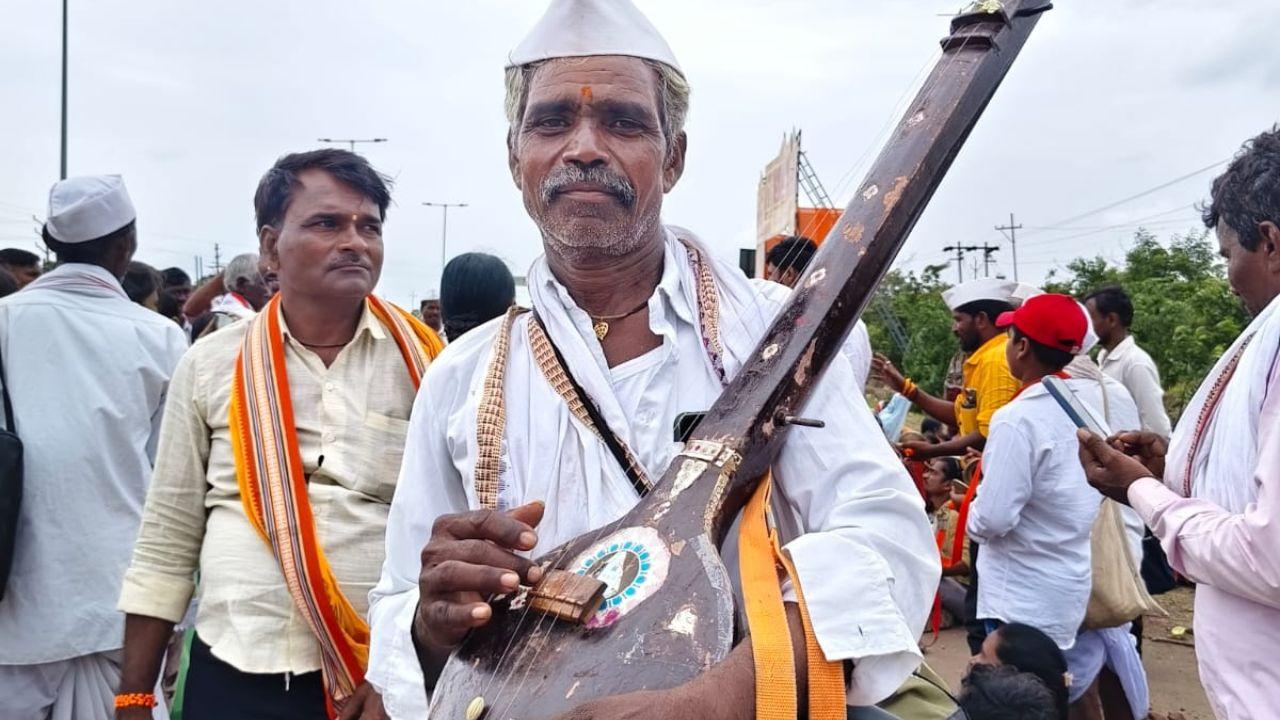 The warkaris walk with palkhis carrying padukas of the saints, singing sacred songs