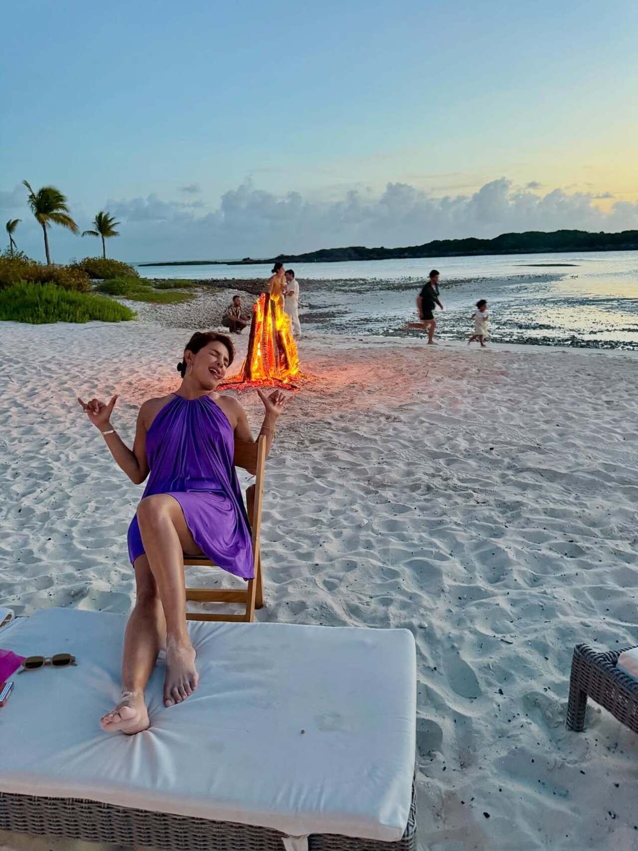 Just the relaxing mode: The diva is busy relaxing by the beach in her pretty purple dress. We could even spot a bonfire amid the scenic view 