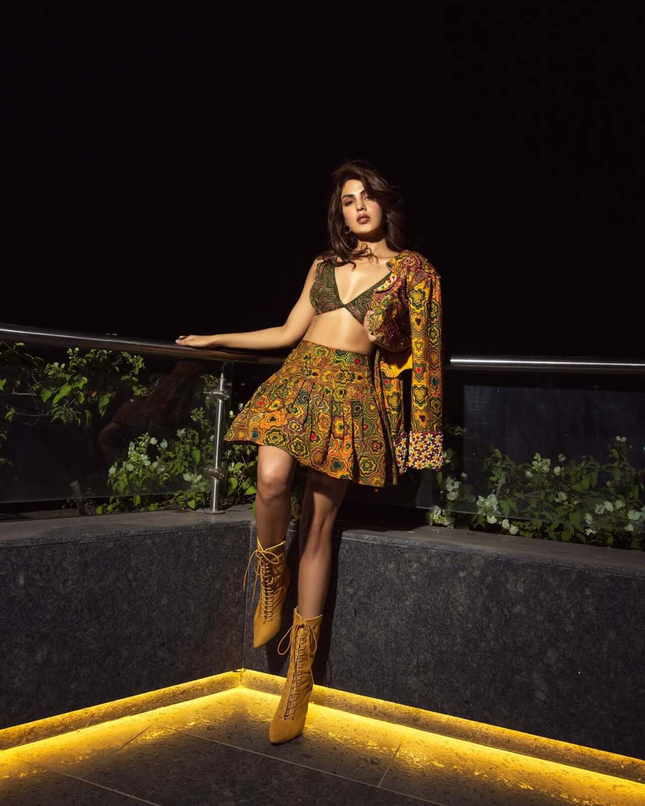Folklore meets power muse. The mirror-work skirt and bralette feel festive, but she flips the script with ochre lace-up boots and a power stance. It’s not fusion—it’s fashion with fire