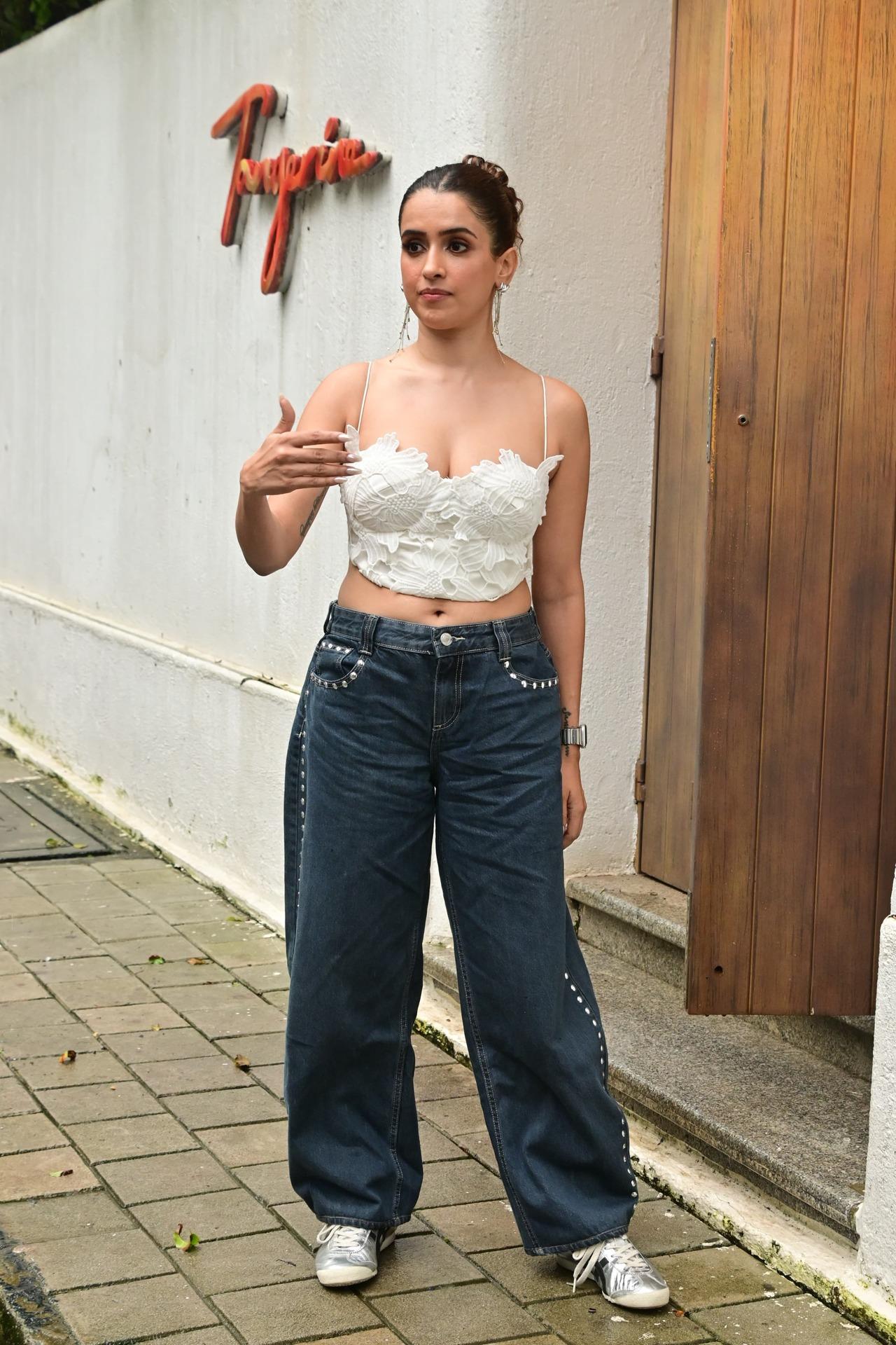 For her outing, she opted for a stunning white strapless top and blue baggy jeans. She tied messy bun and flashed her bright smile while posing.