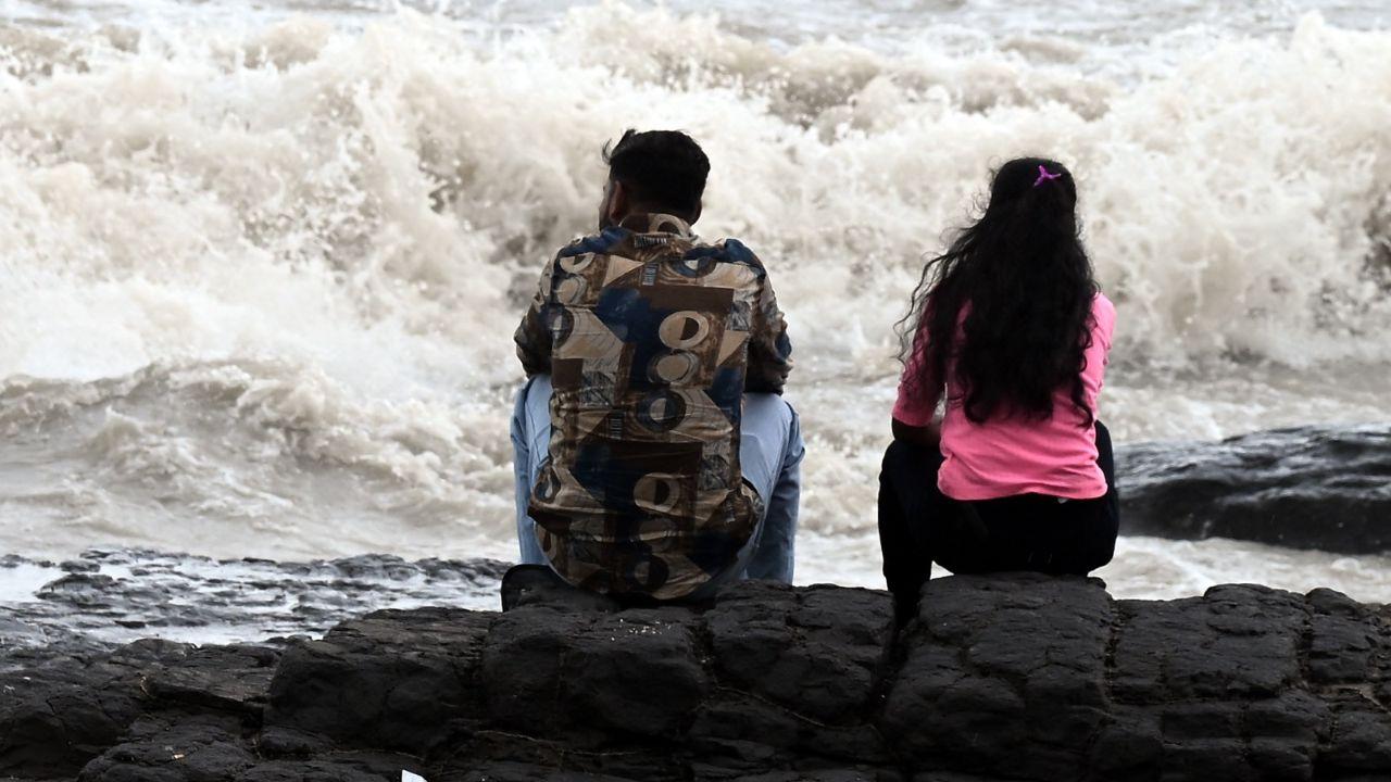 People were seen clicking pictures with their friends and families for photos, as the sea churns violently under an overcast sky