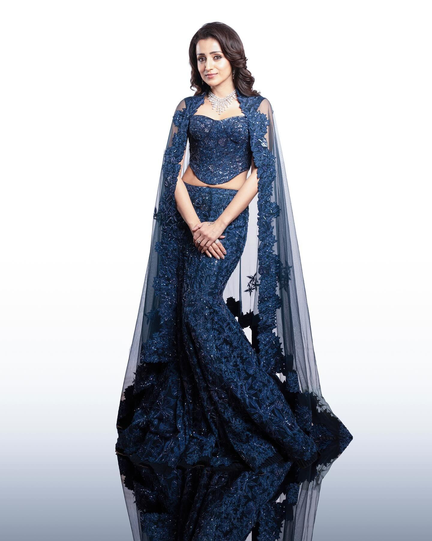 Trisha Krishnan looked absolutely mesmerising in this navy blue mermaid lehenga, a asymmetrical blouse and a net cape. She stole the show in this beautiful outfit at Thug Life's music launch. 