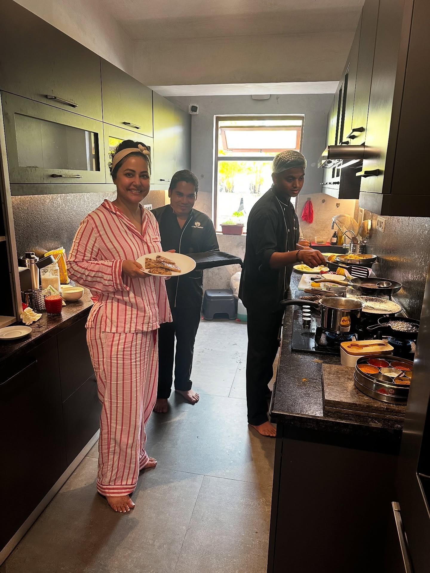 Hina also shared a photo of herself making and enjoying a meal with the cooks in the kitchen. A true foodie!