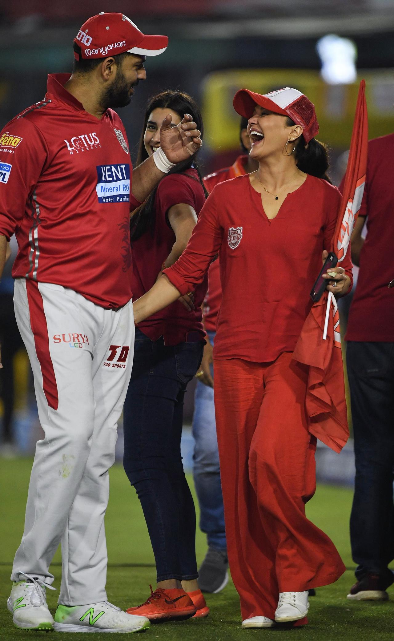 So effortlessly stylish yet captivating, Preity rocks every shade of red like no other. In a loose tee, flared palazzo pants, PBKS flag, and cap, she’s a walking fashion statement—proud and bold