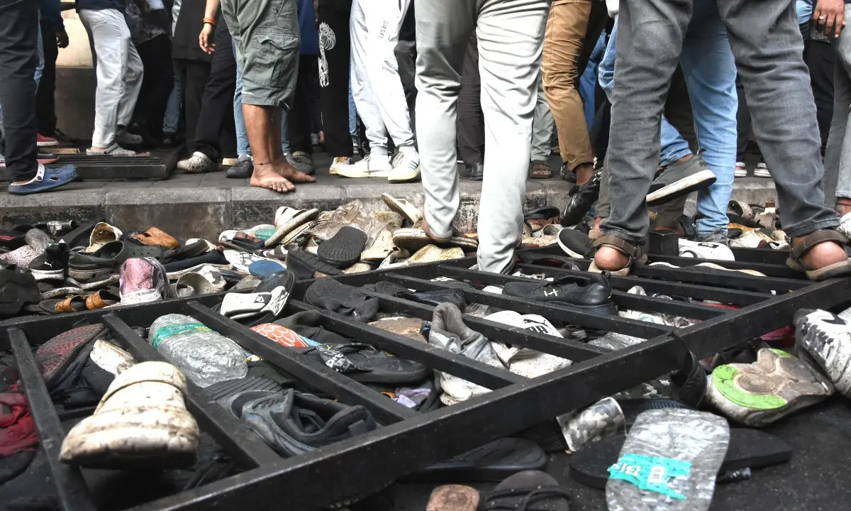Fans stand next to abandonned shoes and a fallen barrier following a stampede during celebrations (Pic: AFP)