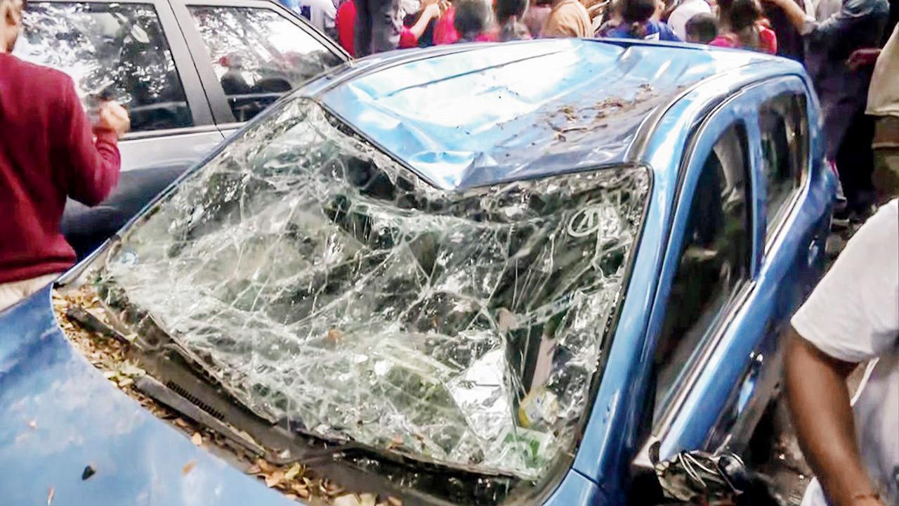 Un automóvil está dañado cuando los fanáticos se suben por el estadio ayer. Pic/AFP