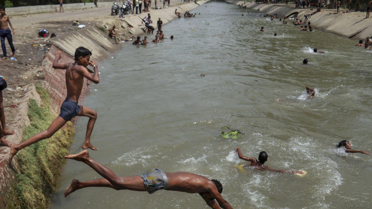 Following an intense heatwave in the city, boys were observed jumping into a canal, seeking relief from the extreme heat
 
