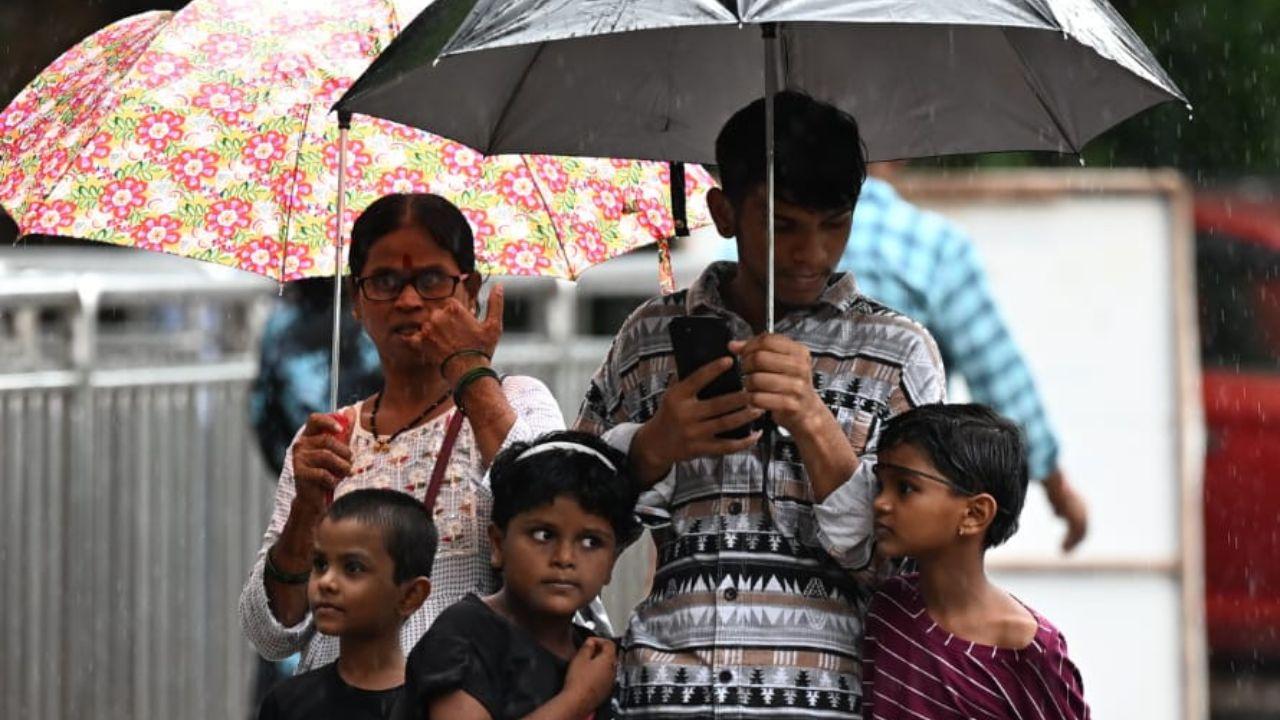 A family was seen taking shelter under umbrellas in Byculla due to the downpour