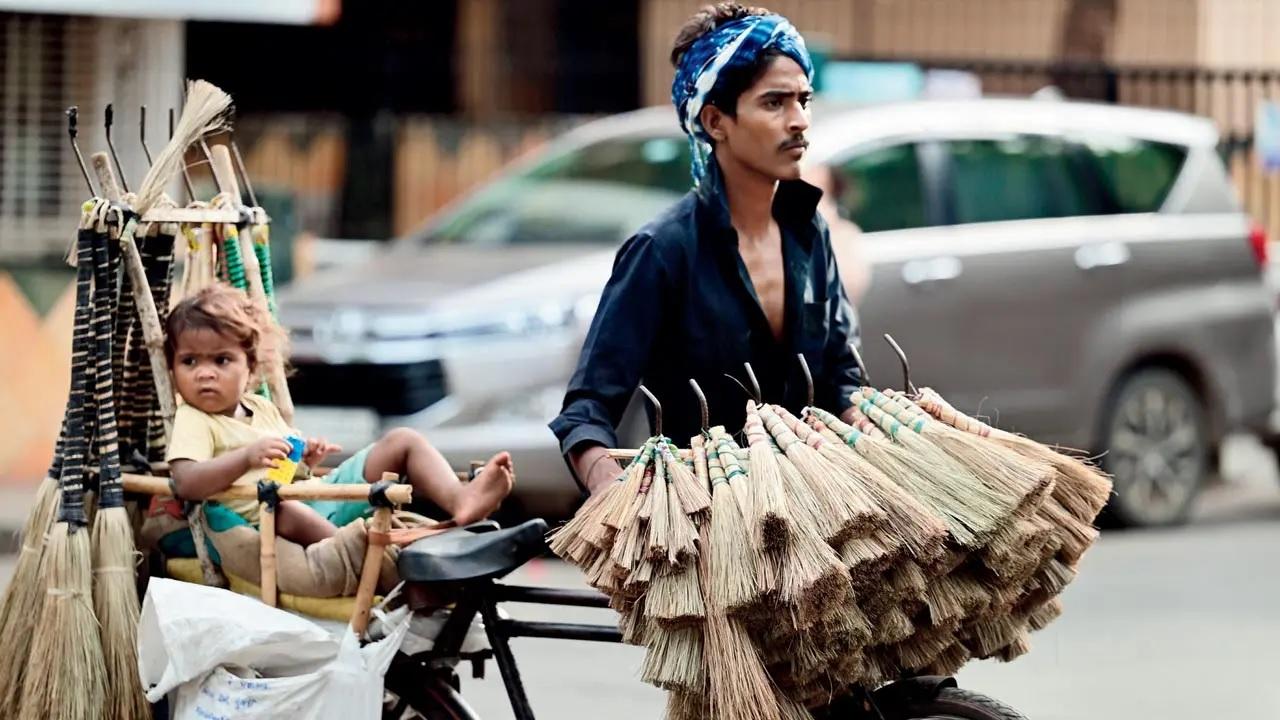 Juggling between working and life like always, fathers still manage to make time for their children, just like this child accompanies the father as he goes about selling brooms in Kandivli. Pic/Nimesh Dave