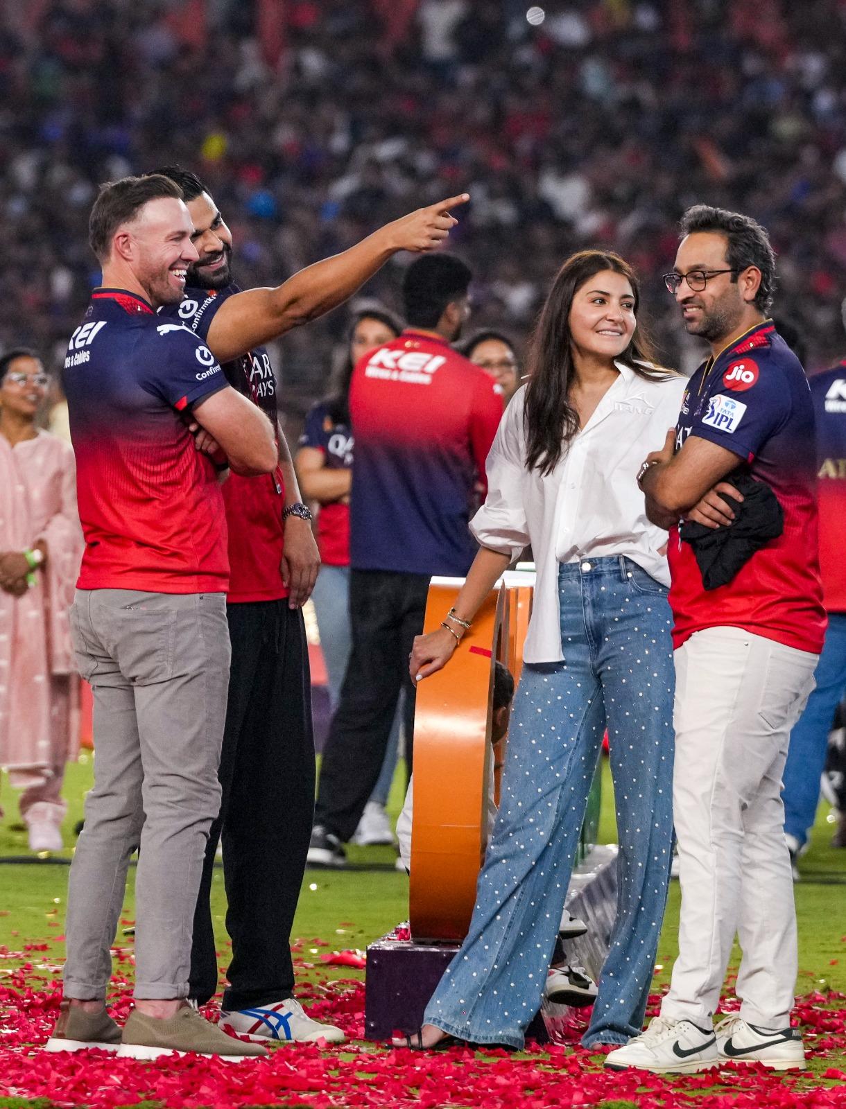 'One with the boys’: Anushka kept it simple in a white shirt and denim, yet looked angelic—especially with her golden stack—letting RCB’s victory shine