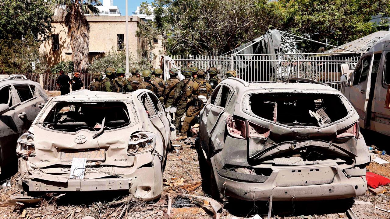 Charred vehicles at the site of an Iranian missile attack near Tel Aviv yesterday. Pics/AFP