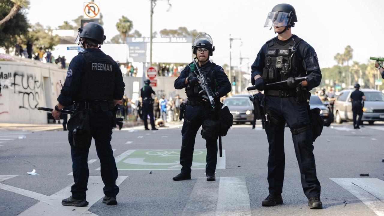 Starting in the morning, National Guard troops stood shoulder to shoulder, carrying long guns and riot shields outside the Metropolitan Detention Centre in downtown Los Angeles