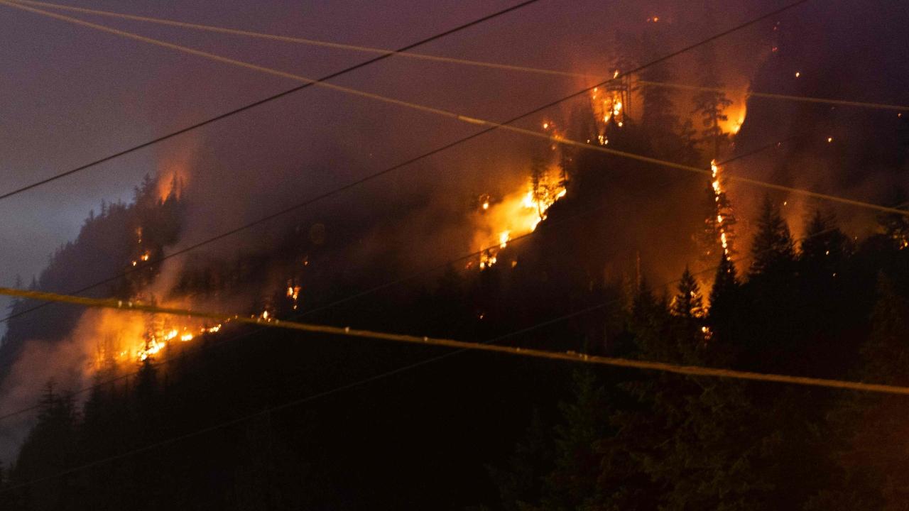 Photos shared by the department showed flames burning alongside and in the median of the highway as wind gusts fanned smoke