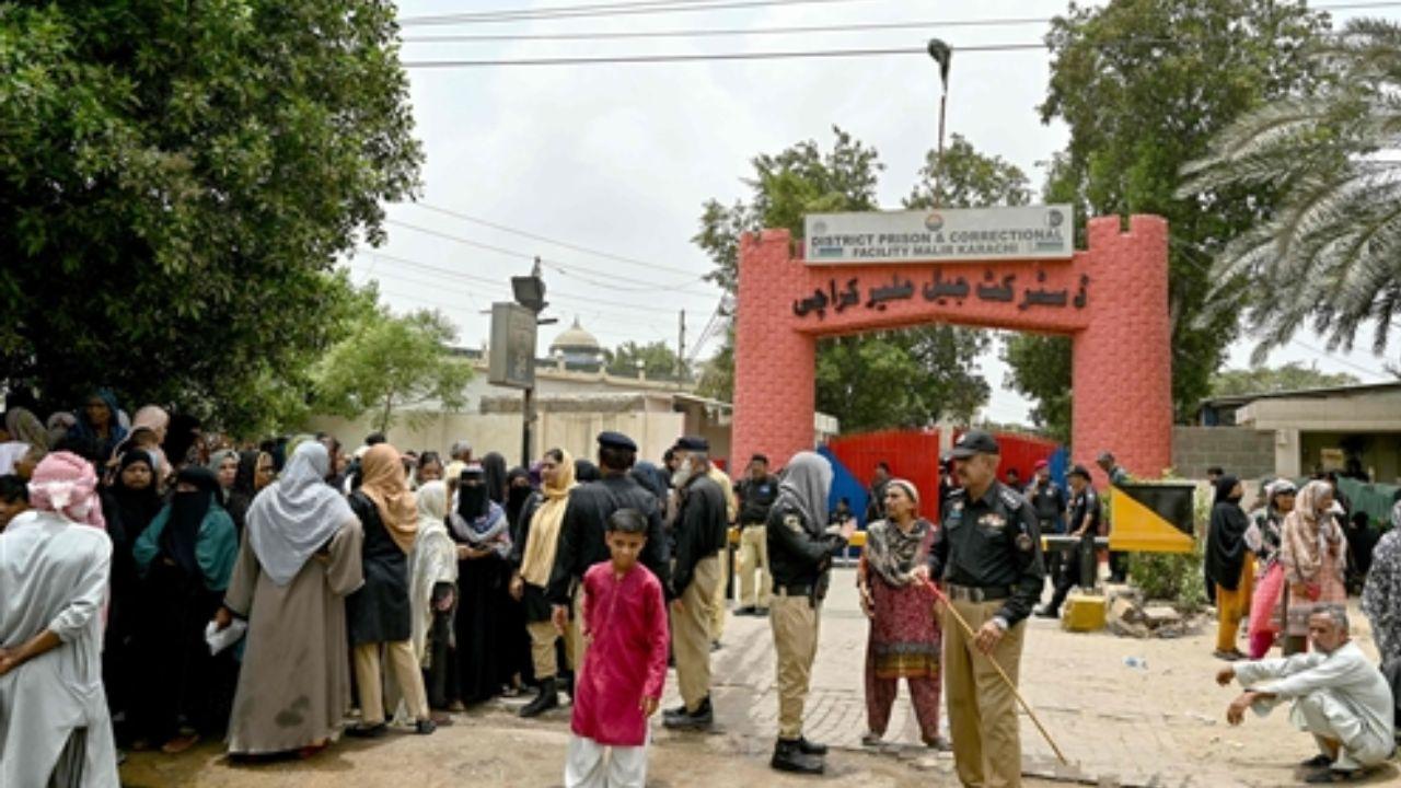 Police personnel assist relatives of convicts gathered outside a prison in Karachi’s Malir district following an overnight prisoner escape caused by earthquake panic