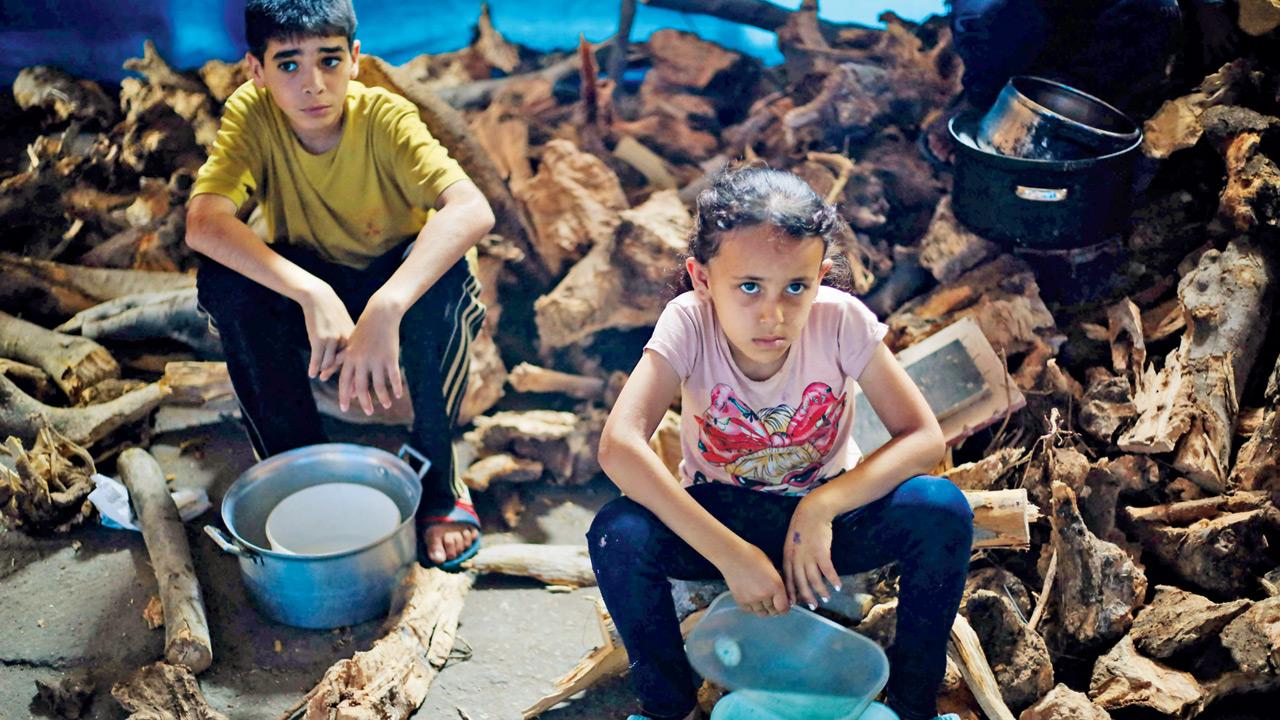 Los niños palestinos esperan comida en un punto de distribución en Nuseirat, Central Gaza Strip, el lunes