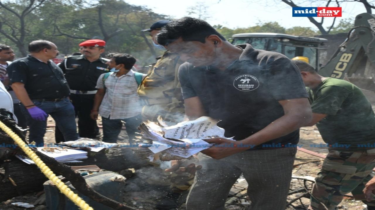 Rescue personnel sift through the charred remains of the wreckage, searching for survivors