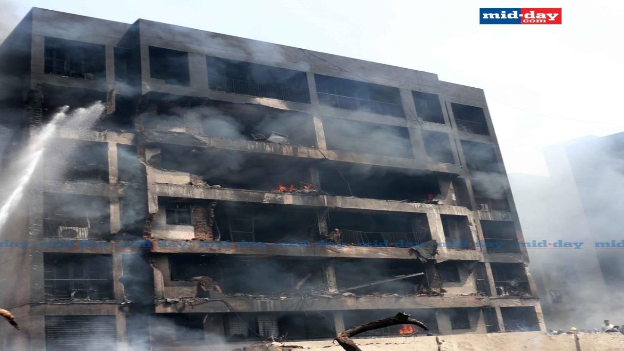Firefighters attempt to douse the blaze at the hostel after the aircraft crash