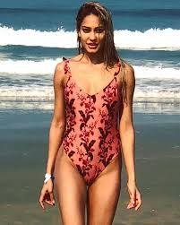 This printed swimsuit is way too elegant and graceful. Although the prints are bright and big, the shape of the swimwear makes it one of her best looks.