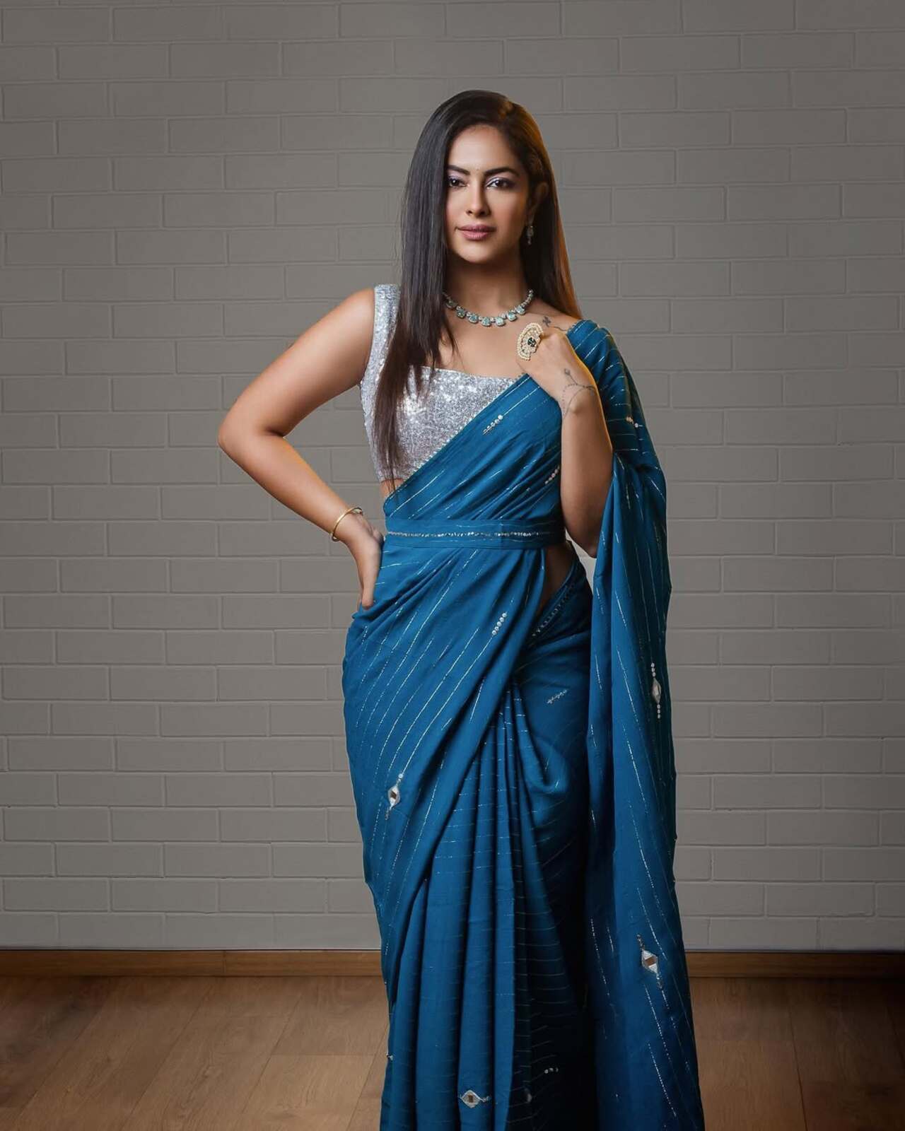 Modern and magnetic, Avika paired a shimmering silver blouse with a teal saree featuring linear detailing. Her sleek hair and diamond jewellery pull the entire fusion-forward look together