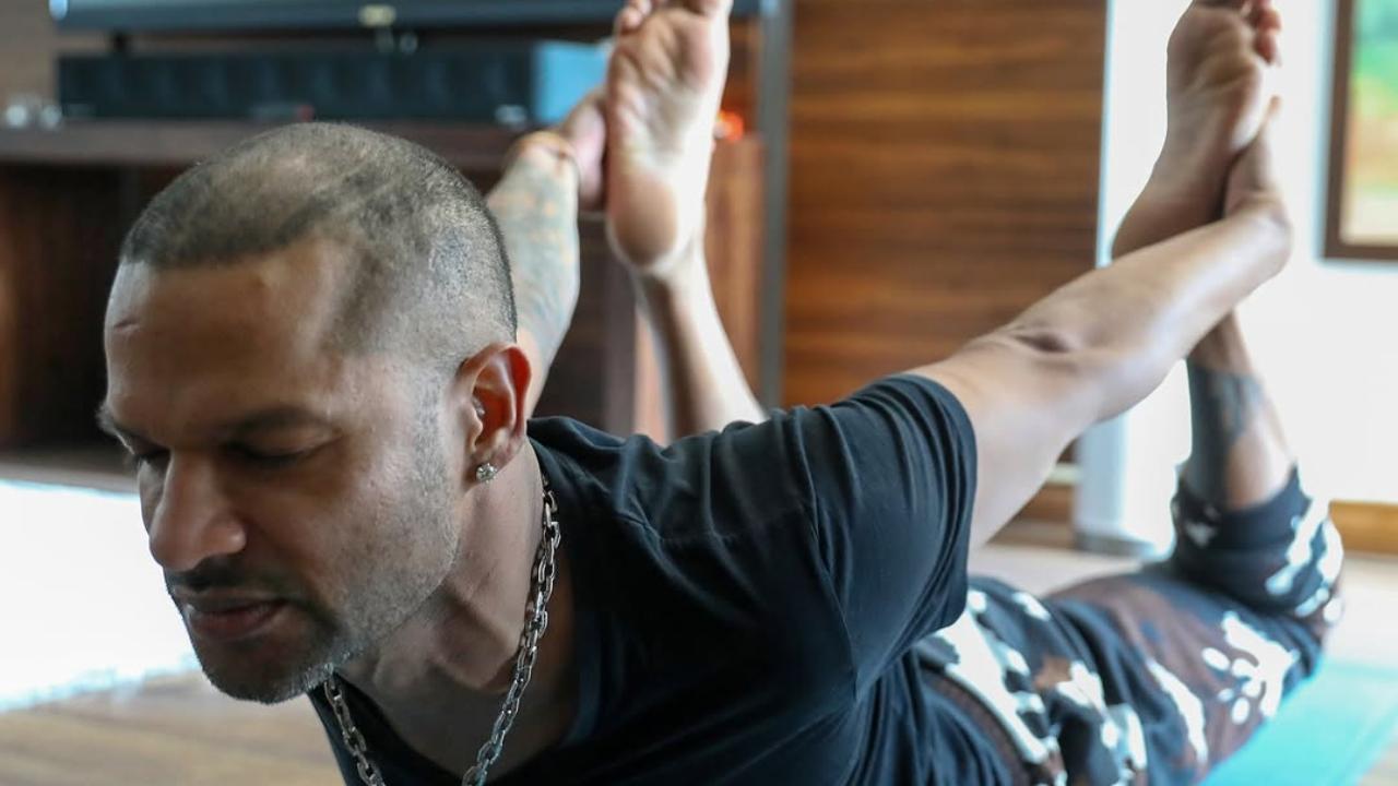 Shikhar Dhawan, known for his flamboyant stroke play, is shown performing the Bow Pose (Dhanurasana)